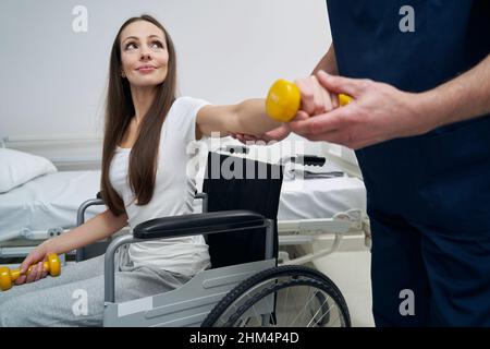 Young disabled woman undergoing physiotherapy session with qualified physiatrist Stock Photo