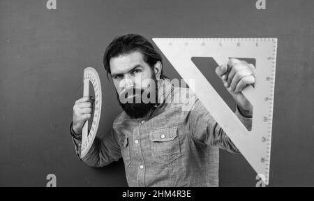 formal education. male student at mathematics school lesson. pass the math exam. learning the subject. serious man with beard using triangle ruler Stock Photo