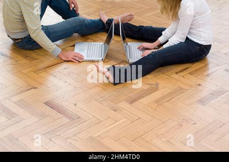 Low Section View Of A Man And A Woman Using Laptops, Credit:Photoshot Creative / Stuart Cox / Avalon Stock Photo