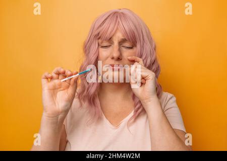 Sad woman complaining holding a pregnancy test, long awaited pregnancy. Stock Photo