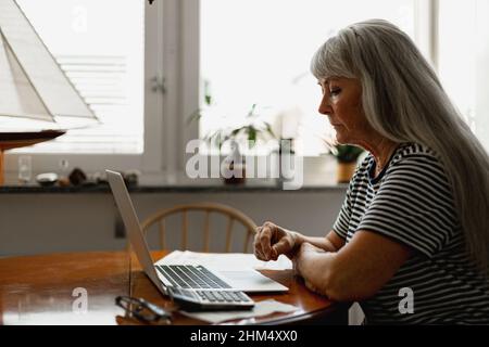 Senior woman using laptop Stock Photo