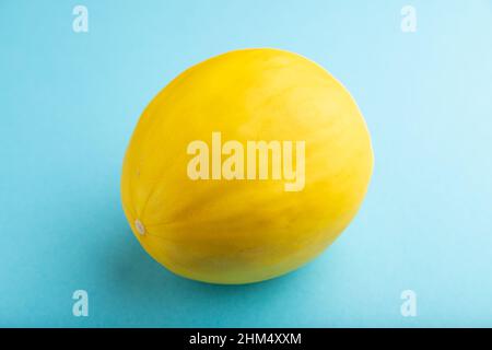 Ripe yellow melon on blue pastel background. Side view, close up. harvest, healthy, vegan food, concept, minimalism. Stock Photo