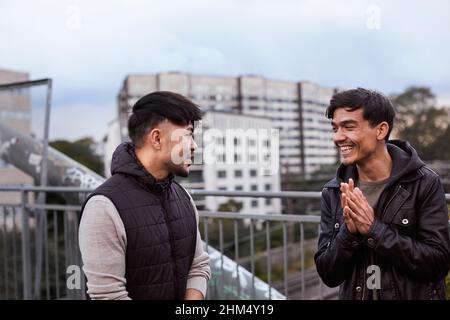 Male friends talking together Stock Photo