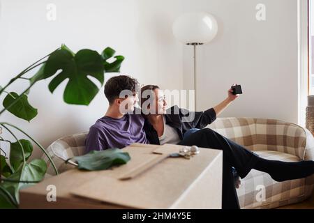 Young couple on sofa taking selfie Stock Photo