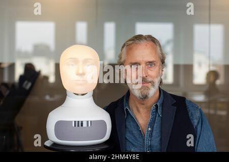 Portrait of senior man with robot voice assistant Stock Photo