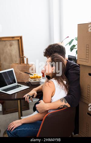 Couple sitting at table and using laptop Stock Photo