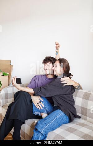 Young couple on sofa taking selfie Stock Photo
