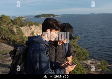 Smiling male friends standing at sea Stock Photo