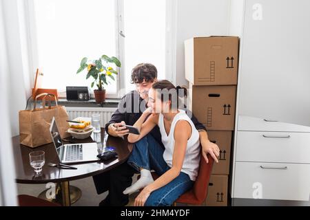 Couple sitting at table and using smart phone Stock Photo