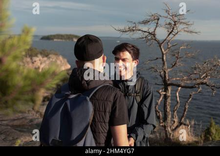 Smiling male friends standing at sea Stock Photo