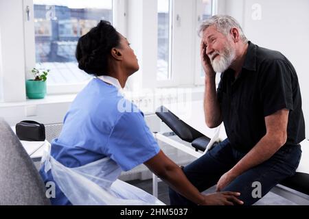 Senior man with headache having doctor appointment Stock Photo