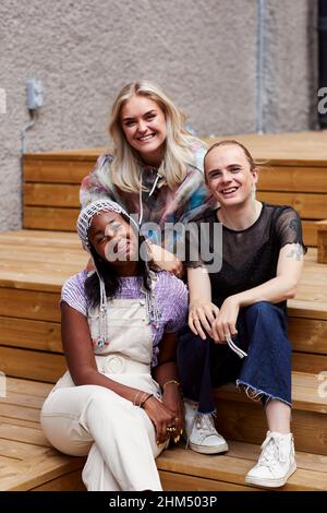 Young friends sitting on stairs Stock Photo