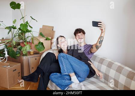 Young couple on sofa taking selfie Stock Photo