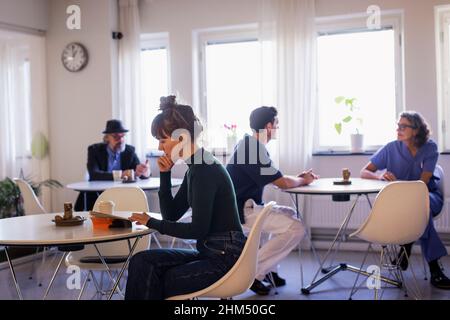 Doctors and patients sitting in waiting room Stock Photo
