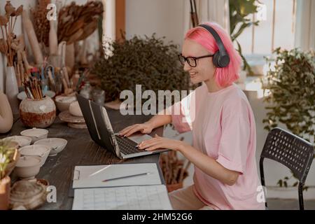 Cute female potter involved in work in her workshop Stock Photo