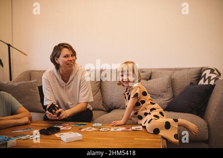 Smiling mother and daughters on sofa Stock Photo