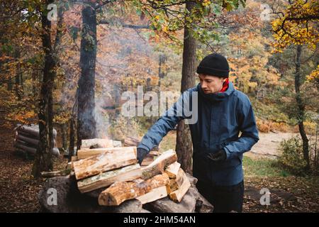 Man making campfire in forest Stock Photo