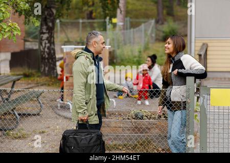 Man and woman talking at gate Stock Photo