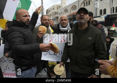 Nablus, Palestine. 07th Feb, 2022. Palestinians carry loaves of bread during the protest against the high cost of living and high taxes imposed by the Palestinian Authority in the Askar refugee camp near the city of Nablus in the occupied West Bank. Credit: SOPA Images Limited/Alamy Live News Stock Photo