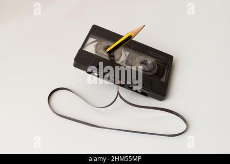 Vintage Audio Cassette Tape with a pencil in the hole to rewind the outside tape. Technology from the 90s. Stock Photo