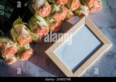 wooden picture frame with decorations. Mock up for your photo or text Place your work, print art.Holiday mock up, corel, orange roses Stock Photo