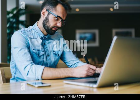 Serious man taking notes while working Stock Photo