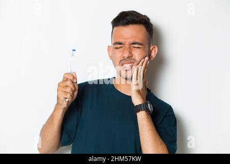 man with toothache; portrait of man suffering from toothache pain, tooth decay, tooth sensitivity; oral health care, dental care concept on white back Stock Photo