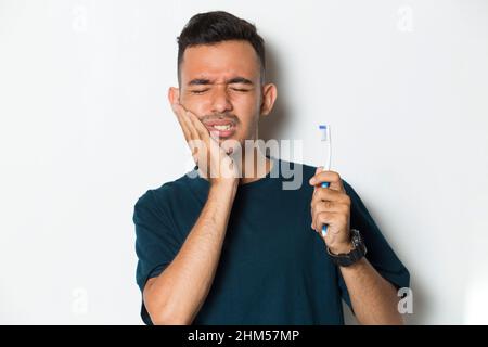 man with toothache; portrait of man suffering from toothache pain, tooth decay, tooth sensitivity; oral health care, dental care concept on white back Stock Photo