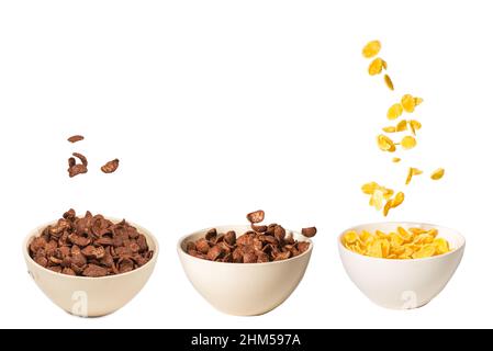 Corn flakes falling to the white bowl. Motion. Copyspace. Isolated on white. Stock Photo