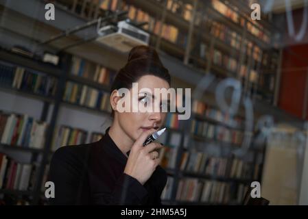 Young professional female writing down a formula Stock Photo