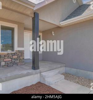 Square White puffy clouds Side view of a porch with concrete flooring and empty garden Stock Photo