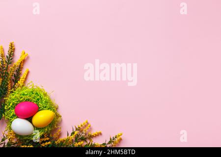 Top view of easter eggs and flower twigs on pink background. Flat lay with copy space Stock Photo