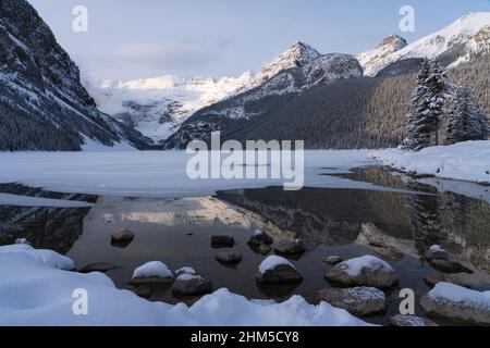 A view of a partially frozen Lake Louise in winter, Banff National Park ...
