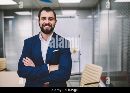 Happy businessman smiling and looking at camera in modern office Stock Photo