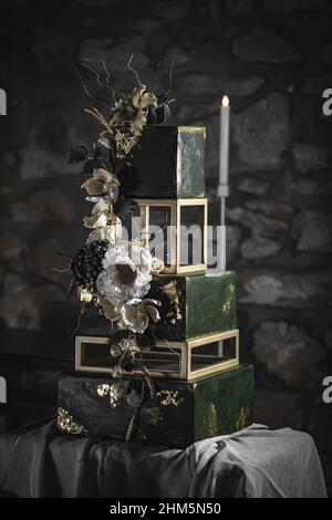 Tiered wedding cake in the form of square in dark green color decorated with flower Stock Photo