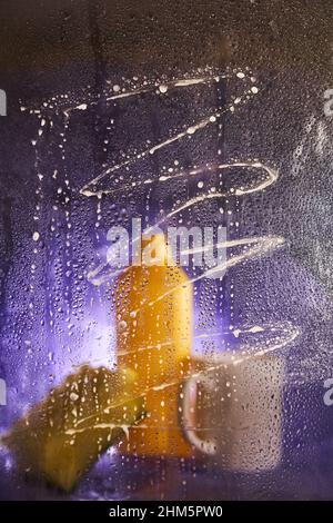 View through dirty glass. Close-up of household cleaning products and kitchen accessories. On a dark lilac background. High quality photo Stock Photo