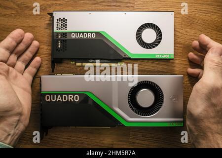 Paris, France - Mar 28, 2019: POV Beautiful senior engineer hands pov near two new GPU Nvidia Quadro RTX 4000 RTX 5000 video cards based on the Turing microarchitecture, and features real-time ray tracing Stock Photo