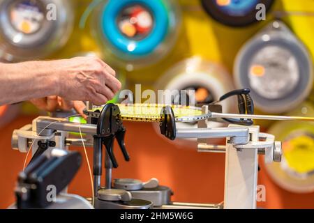 manual stringing of a badminton racket in service Stock Photo