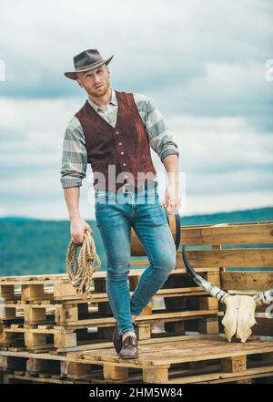 Cowboys are gentlemen. wild west rodeo. man in hat outdoor. man checkered  shirt on ranch. Vintage style man. Wild West retro cowboy. cowboy with  lasso rope. Western. western cowboy portrait Stock Photo