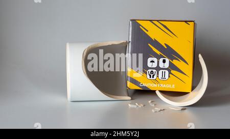 Fragile cargo shipment. Broken mug glass. Mug broken during cargo transportation. Cup protection box. no careful cargo that can be used by the seller Stock Photo