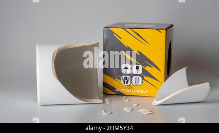 broken mug cup. Fragile cargo shipment. Mug glass broken during cargo transportation. storage box. image of what happens if there is no careful cargo Stock Photo