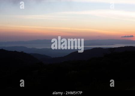 View at sunset towards the Gulf of Nicoya from cloud forest near Santa Elena, Monteverde, Costa Rica. Stock Photo