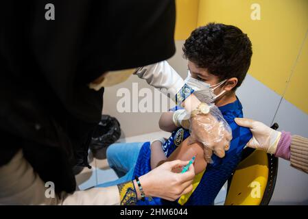 Tehran, Iran. 05th Feb, 2022. An Iranian boy who is 11 and wearing a protective face mask receives a dose of China's Sinopharm new coronavirus disease (COVID-19) vaccine in the Iranmall shopping complex in northwest of Tehran. (Photo by Sobhan Farajvan/Pacific Press) Credit: Pacific Press Media Production Corp./Alamy Live News Stock Photo