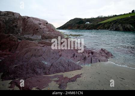 Talland Bay Looe Cornwall situated between Looe and Polperro Cornwall England UK. Unusual coloured rocks, Sedimentary green and pink slate Stock Photo