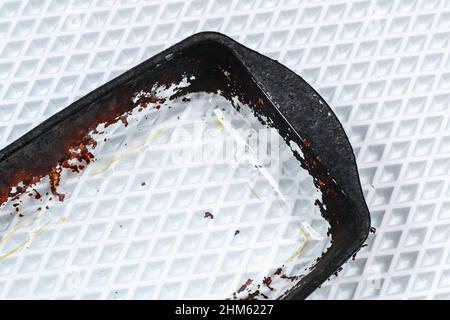 Dirty baking dish with a thick layer of carbon. Glassware for baking with soot, carbon deposits, old dried fat. Stock Photo