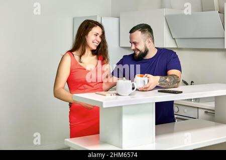 Flirl in office kitchen between cheerful employees. Stock Photo