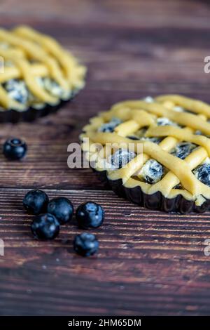 Small cups of delicious blue berry tart or pie  on wood table background. Stock Photo