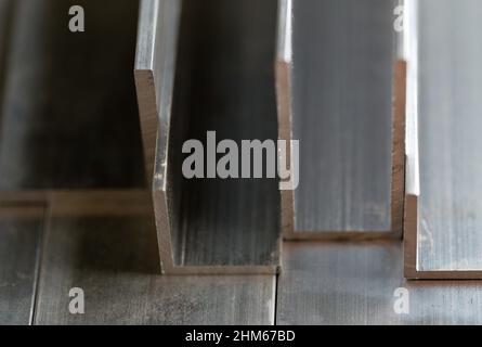 Abstract stack of aluminium profiles close up, industrial background macro, selective focus Stock Photo