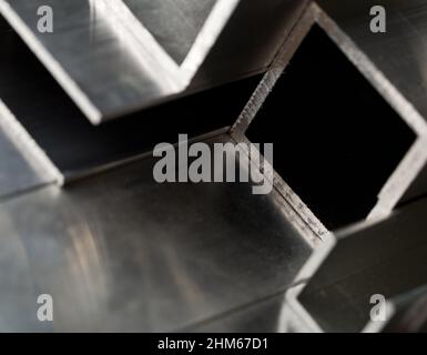 Abstract stack of aluminium profiles close up, industrial background macro, selective focus Stock Photo