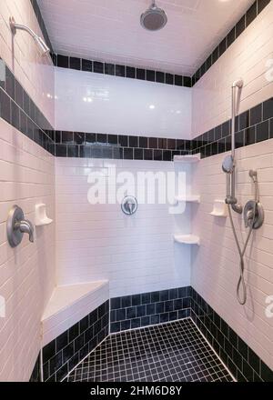 Vertical Bathroom interior with black and white tile flooring and walls Stock Photo